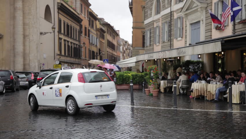 Rome - MAY 8, 2012: Cars and tourists pass by a Roman cafe on rainy day