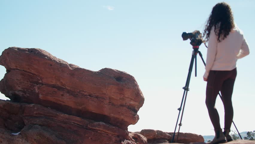 Woman photographing the striking red rock formations at Garden of the Gods, Colorado