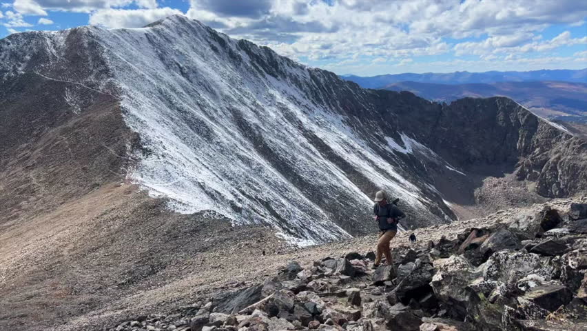 Hiker on Mount Lincoln loop Kite Lake Trail hiking 14er Rocky Mountains Colorado dusting Bross Cameron Democrat Grays Torreys Quandary mountaineering peaks fall first snow dusting blue sky morning pan