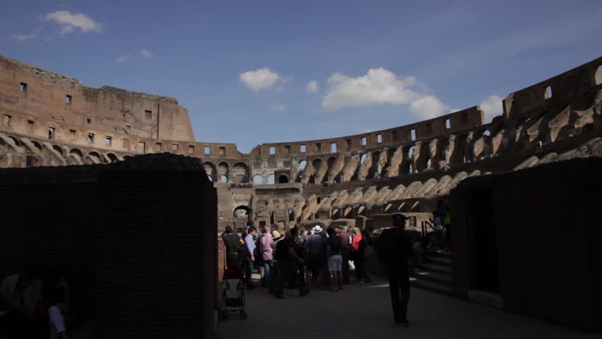 ROME - CIRCA MAY 2012: Tourists survey the ruined arena of the Colosseum 