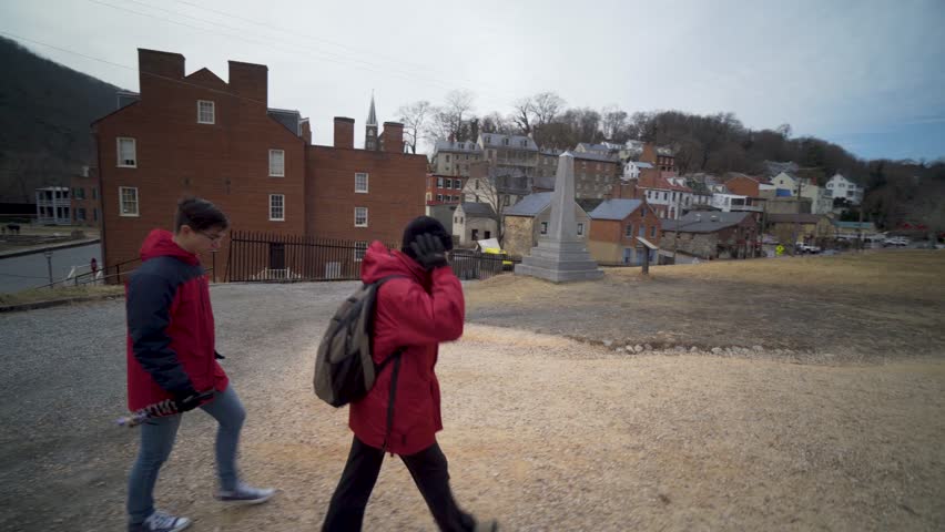 Mature woman and her teenage son walk along a berm talking and pointing to places in Harpers Ferry National Park in Harpers Ferry, WV.