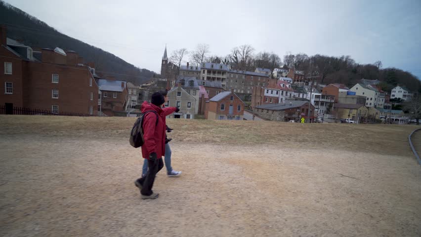 Mature woman and her teenage son walk along a berm talking and pointing to places in Harpers Ferry National Park in Harpers Ferry, WV.