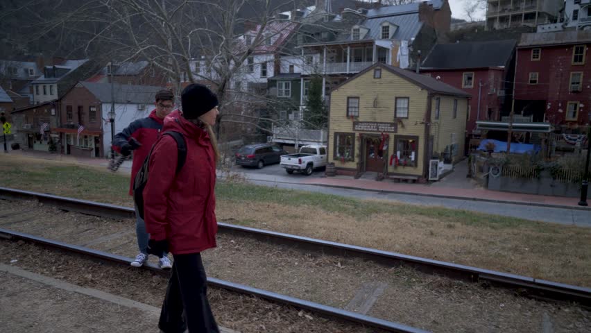 Mature woman and her teenage son walking along a railroad track beside Harpers Ferry National Park in Harpers Ferry, West Virginia.