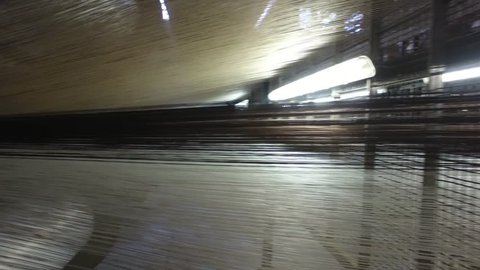SHYMKENT, KAZAKHSTAN - NOVEMBER 22 2017: Carpet factory. Thousands of threads going to a mechanical loom