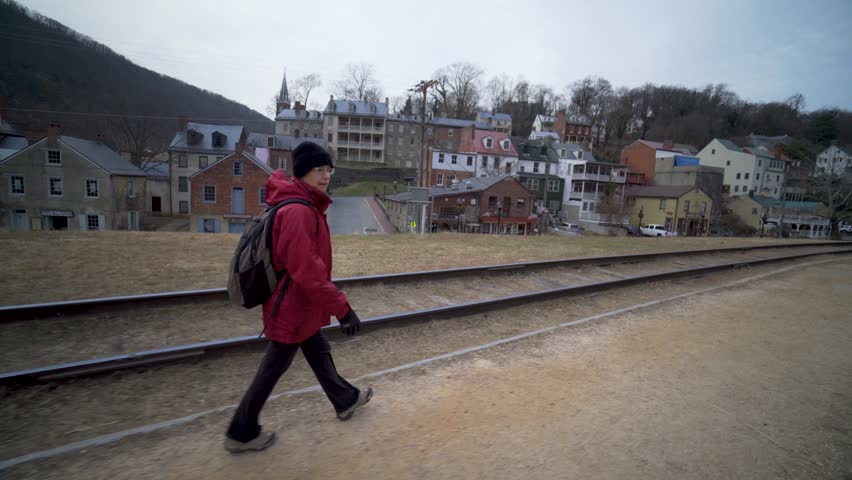 Mature woman walking along a railroad track beside Harpers Ferry National Park in Harpers Ferry, West Virginia.