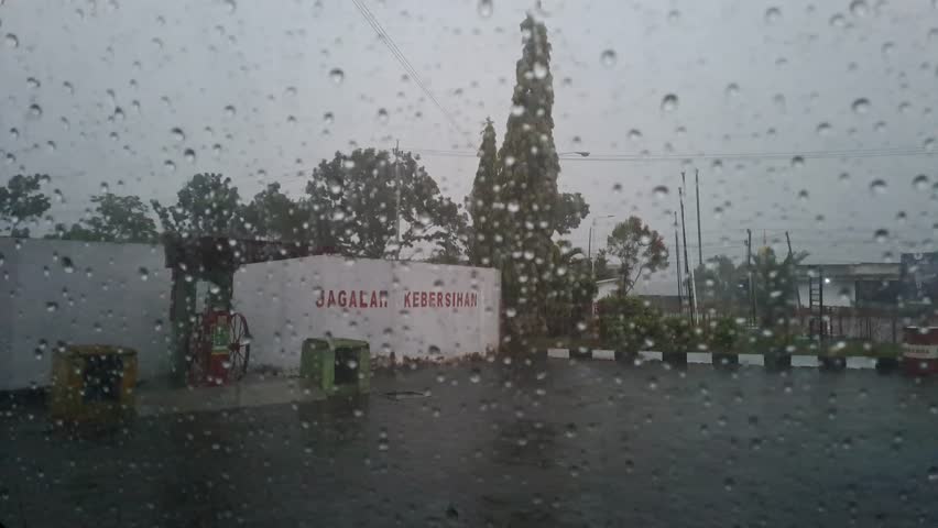 Blurrred background of the car window looks aesthetic because it is wetted by raindrops.