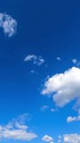 Amazing bright blue sky with little clouds flying through. Beautiful timelapse of fluffy clouds transformation. Vertical video.