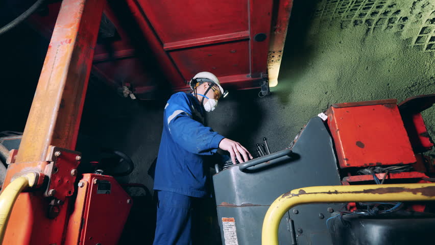 Industrial worker is operating minery equipment underground