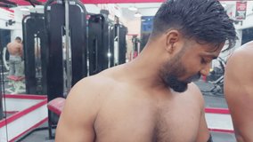 Closeup two Fit man smiling talking standing confidently in a gym setting showcasing his muscular physique motivation video for gym Asia india