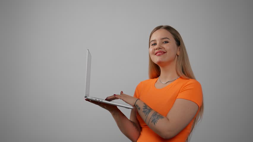 Young smiling woman typing on laptop. Happy young freelance business lady working, watching webinar, using online app, holding computer, smiling at home. Job, administration social manager concept. Royalty-Free Stock Footage #3458078973