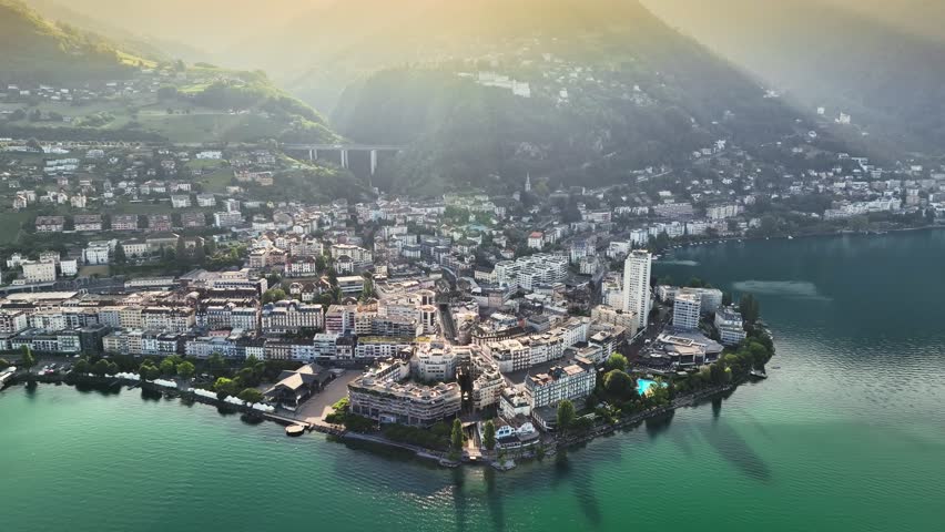 Flying over Lake Geneva, view to Montreux city center and green hills at sunrise. Aerial view of Montreux, Switzerland