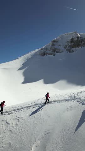 Three mountaineers walk on the peak of snow covered mountain. They wears ice climbing equipments. Mountaineering, climbing, alpinism concept. Royalty-Free Stock Footage #3458099641