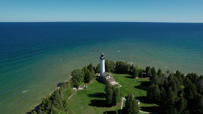 Drone aerial view of a white light house over looking lake Michigan