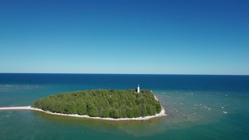 Drone aerial view orbiting a light house on the shores of Lake Michigan