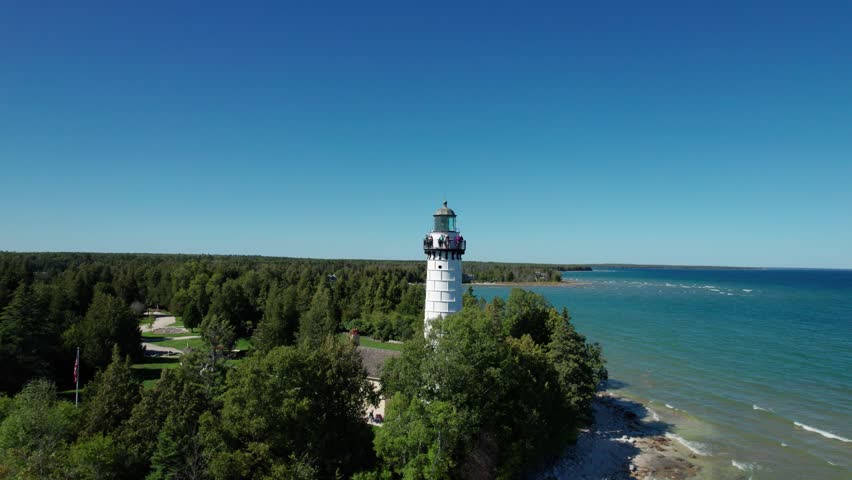 Drone aerial shot pulling back from a light house on the shores of door county, WI