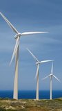 Green renewable alternative energy concept - wind generator turbines generating electricity. Wind farm on Crete island, Greece with small white church