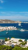 Timelapse of Mykonos town with famous windmills, and port with boats and cruise ship. Mykonos, Cyclades islands, Greece