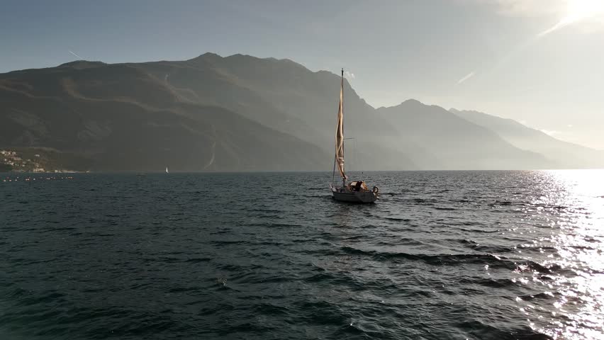 Sailing yacht sailing at sunset. Lake Garda in northern Italy.
