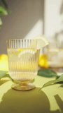 Close up of glasses of water with lemon on the table on a sunny summer day. Vertical shot