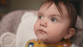 baby dirty eats. happy family toddler concept. baby girl learns to eat with her hands dirty her face dream dirty funny video dirty. baby on the table for feeding eats with her hands from cup