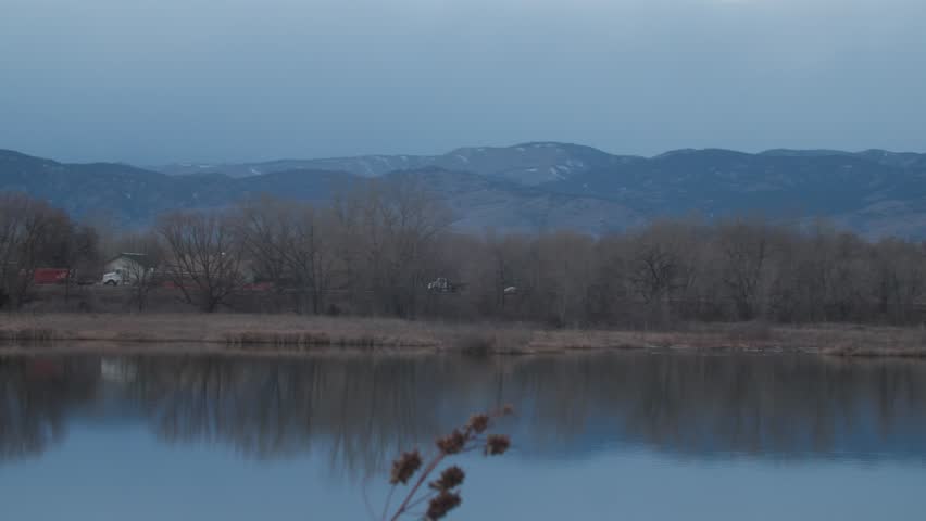 Landscape Panning Across Pond Near Beautiful Mountain Range Blue Lighting