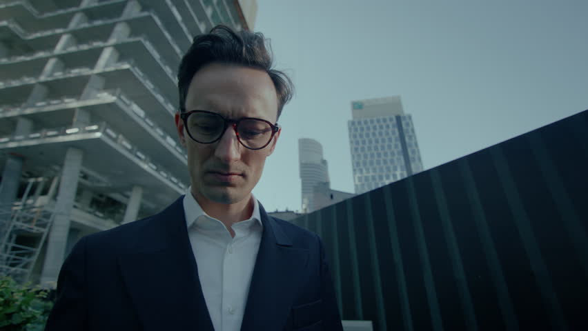 Low angle view of a happy business man talking on his mobile phone with office view at background.