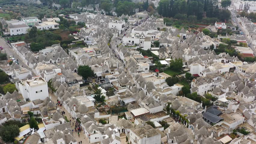 The traditional Trulli houses in Alberobello city, Apulia, Italy. Cityscape over the traditional roofs of the Trulli, original and old houses of this region, Apulia, Alberobello, Puglia, Italy.  Royalty-Free Stock Footage #3458344385