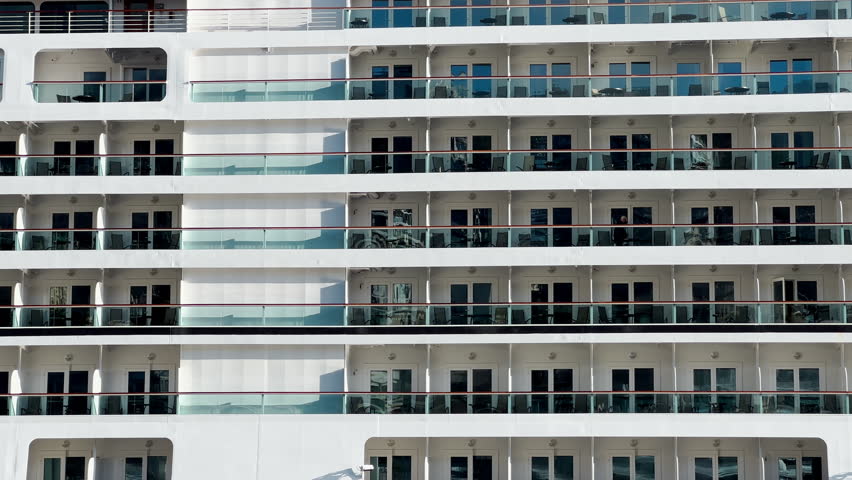 Decks with balconies of a huge cruise ship located in the port of Monaco, deck chairs on the balcony of each cabin