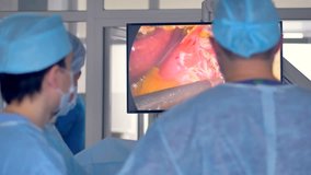 Surgeons manipulate patients organs tissue by means of video feed. 
