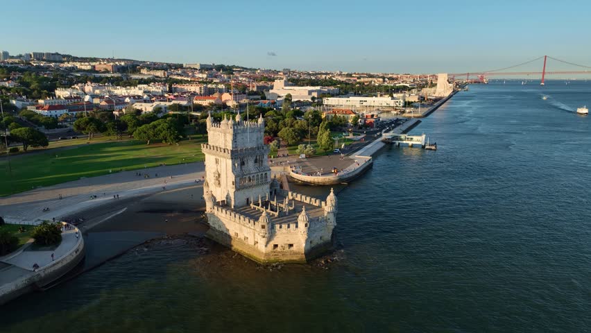 Aerial drone view of Belem Tower famous tourist landmark of Lisboa and tourism attraction on bank of Tagus River with tourist boat at sunset. Lisbon, Portugal. Truck strafe slide shot Royalty-Free Stock Footage #3458410139
