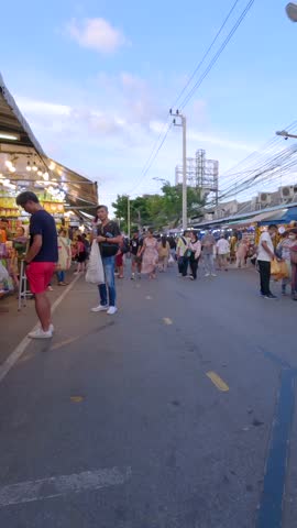 Tourist walking through the Chatuchak Weekend Market in Bangkok, Thailand. POV