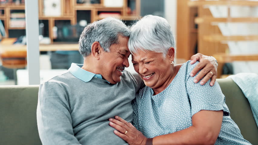 Senior couple, hug and laughing on sofa with conversation for funny memory with love, care and bonding. Old man, elderly woman and happy with embrace, connection and remember with comic chat in home Royalty-Free Stock Footage #3458546435