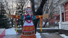 Vintage Maslenitsa female figurine made of improvised materials and brooms instead of hands in a Slavic-style costume for meeting spring and seeing off winter in the city park