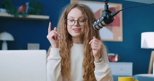 Internet blog, content maker. Female blogger wearing glasses and talking in microphone. Woman radio presenter leading morning show. Radio host saying hello to listeners.