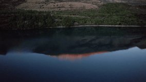 flying backwards to reveal the perfectly reflected snow capped mountains at sunrise in Lake Wakatipu in Queenstown New Zealand - Powered by Shutterstock - Get 15% off with code: PIKWIZARD15