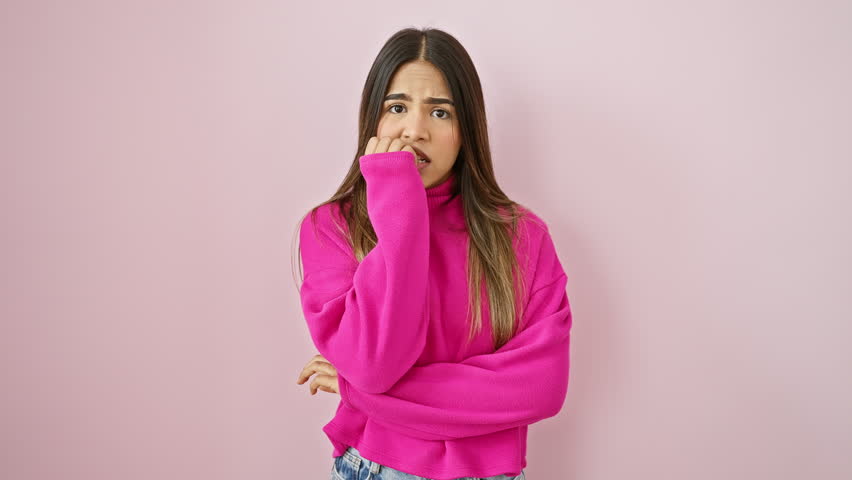 Anxious beauty, young latin woman in sweater, nervously biting fingernails, struggling with stress and anxiety, isolated over pink background Royalty-Free Stock Footage #3459007685