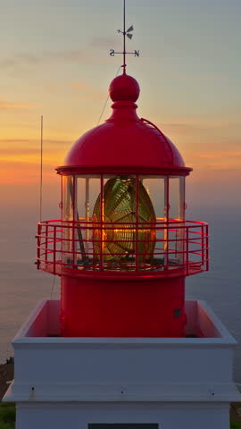 Fantastic aerial shot of lighthouse in Madeira, Portugal at sunset. Aerial view to red and white lighthouse building on sheer rocky cliff Royalty-Free Stock Footage #3459019515
