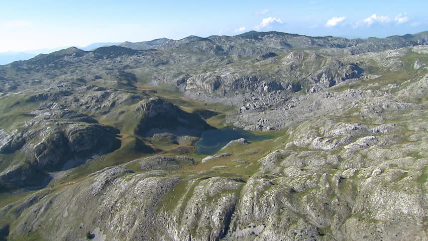 Rocky terrain of Dinaric Alps with beautiful small lake in the center