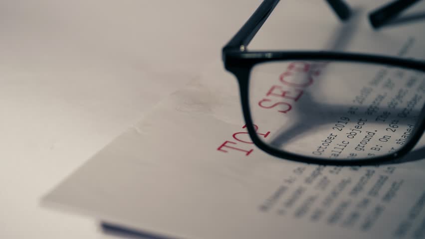 Top secret document with pair of glasses close up 4k dolly selective focus