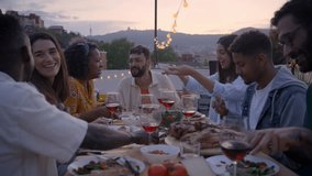Reunion of diverse happy friends eating and drinking sitting in a table in a rooftop terrace on evening event. Gathering of smiling people together dining Mediterranean meal in celebration - Powered by Shutterstock - Get 15% off with code: PIKWIZARD15