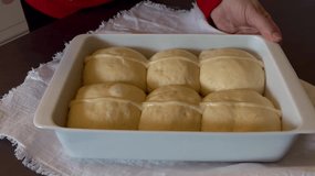 Close up of woman's hands making lines on raw hot cross buns  - Powered by Shutterstock - Get 15% off with code: PIKWIZARD15