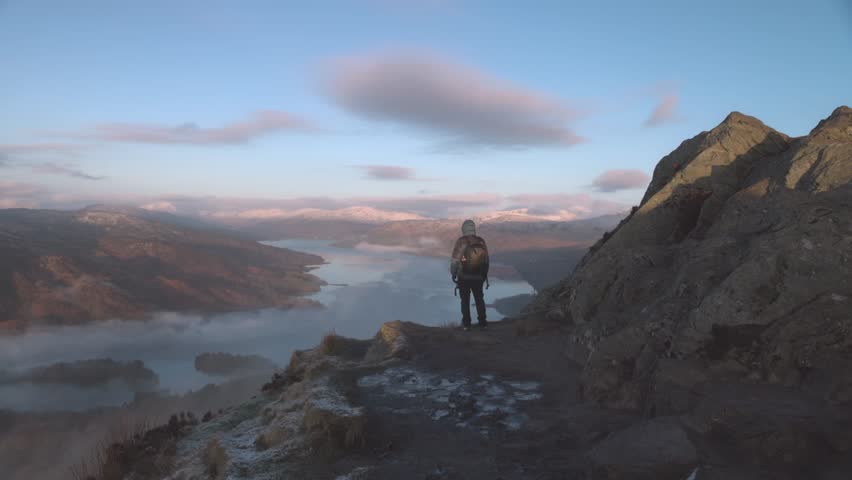 Static shot of a hiker admiring thew views at the summit of Ben A