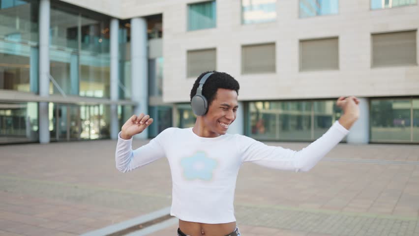 Person dancing and listening to music having fun outdoors in the city.