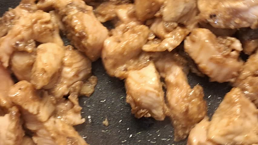 The chef stirs the chicken meat into noodles in a WOK pan. Man