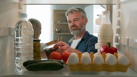 Point of view POV from inside refrigerator middle-aged couple adult man and woman husband and wife talking unpacking shopping bag delivery food package unpack vegetables healthy products in fridge - Powered by Shutterstock - Get 15% off with code: PIKWIZARD15