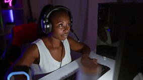 Excited woman with headphones celebrates victory at night in a dark gaming room