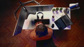 Top down view of fatigued man working overnight at home, rubbing eyes while taking break from coding, feeling sleepy. Tired IT admin exhausted from long screen time, pausing tasks to rest, aerial shot - Powered by Shutterstock - Get 15% off with code: PIKWIZARD15