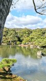 Kinkakuji temple on a pond, Kyoto, Japan. Vertical video in autumn season on a sunny day.