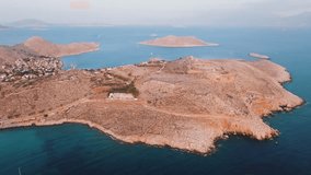 Drone Video of Chalki Island on sunset with gentle rolling waves and other Greek islands in distance.