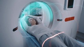 Female patient undergoes MRI or CT scan, lies on bed moving inside the machine. Visual effects of scanning brain and body of woman. High-tech extended reality equipment in advanced medical laboratory. - Powered by Shutterstock - Get 15% off with code: PIKWIZARD15